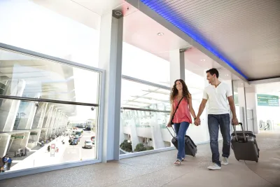 Happy couple walking across a sky bridge at the San Diego International Airport