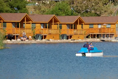 Lakefront cabins overlooking Santee lakes as a father daughter fish off of a pontoon boat