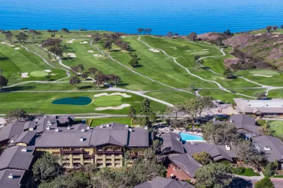 Aerial shot of the Lodge at Torrey Pines Resort with the Torrey Pines Golf Course stretching out toward the Pacific Ocean
