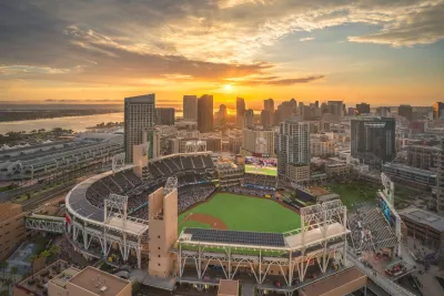 Aerial view of Petco Park stadium at sunset with Downtown San Diego behind it