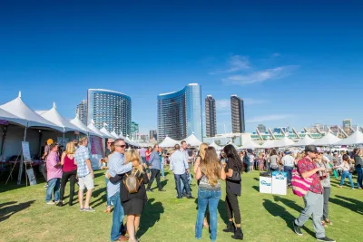 Two lines of tents at the San Diego Wine and Food Festival at Waterfront Park on a sunny cloudless day 