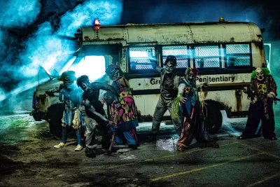 a group of people dresses as zombies and monsters in front of a haunted school bus in San Diego.