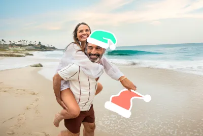 Couple on the beach in San Diego with Santa hat graphics added to their head