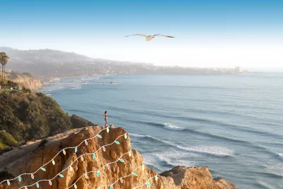 Female hiker standing atop a hill at Torrey Pines Regional State Park with some fun holiday graphics of lights superimposed