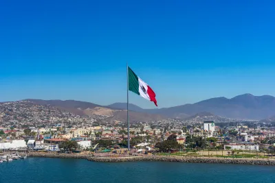 Port of Ensenada with a large flag of Mexico towing over the waterfront promenade
