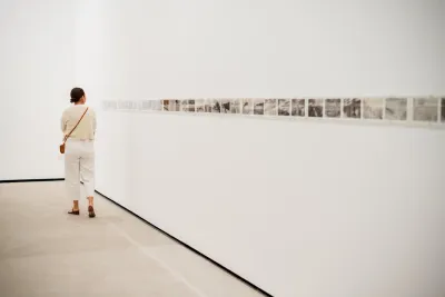 A woman looking at piece of art in an art museum located in San Diego