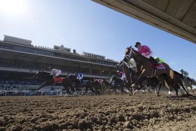 Horses and their jockeys racing on the dirt track at Del Mar Thoroughbred club