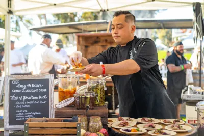Chef Amy di Biase plating food during the San Diego Food and Wine Festival 