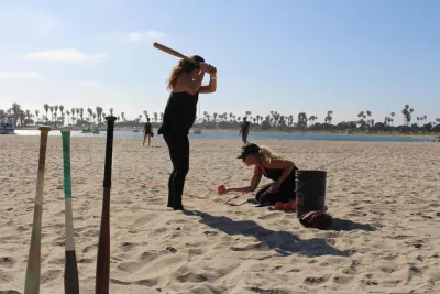A woman at bat during the Over the Line Tournament on the sand on the beach in San Diego