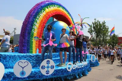A parade float in the Pride Parade with people waving and smiling during the San Diego Pride Parade in Hillcrest. 
