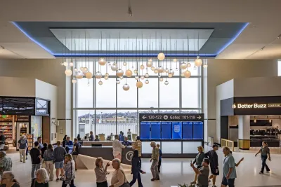 Travelers waiting at Terminal 1 San Diego Airport with art overhead