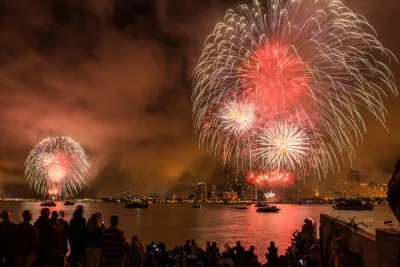 Colorful fireworks for Big Bay Boom illuminate the night sky over San Diego's waterfront for Fourth of July, with spectators watching in awe.