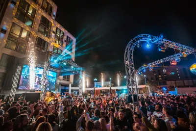 Crowd enjoying a lively outdoor event at night with colorful lights and fireworks at Hard Rock Hotel. 