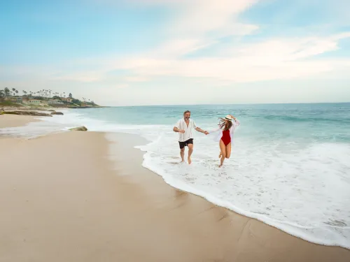 Couple running on a beach in San Diego's La Jolla