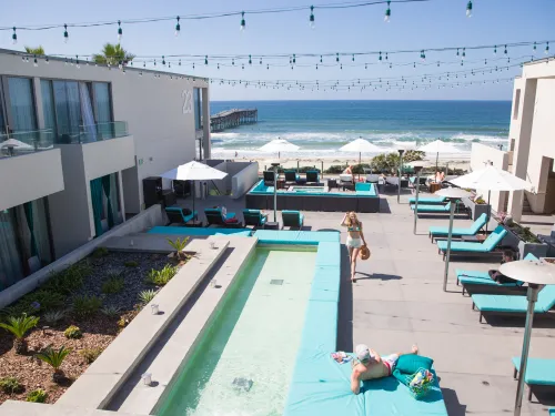 Couple enjoying the pool overlooking the Pacific Ocean at a hotel in San Diego