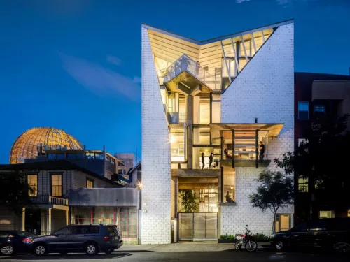 A unique building with the lights on at dusk in San Diego CA