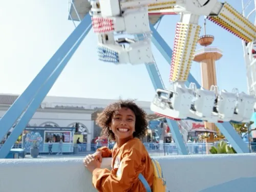 Young girl smiles on ride at Belmont Park along the beach in San Diego, CA