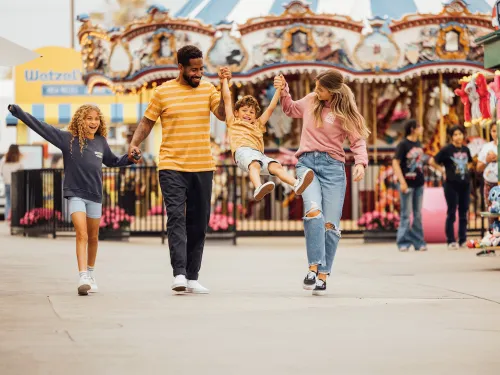Family of four with two kids walking into Belmont Park