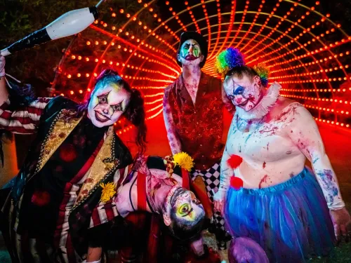 Three scary clowns standing close together looking really creepy and scary at Howl-O-Scream at SeaWorld San Diego