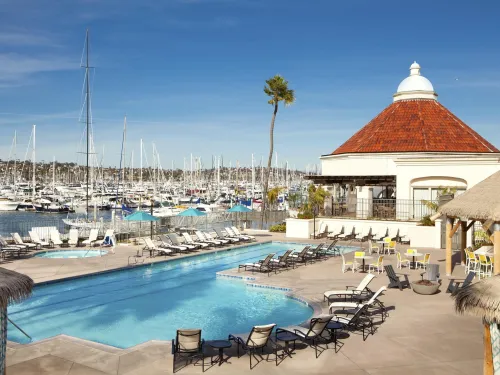 Pool at the Kona Kai on Shelter Island with boats docked in the background under blue skies
