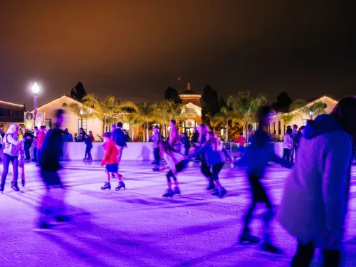 A group of people skating at night on an outdoor ice rink at Liberty Station in San Diego.