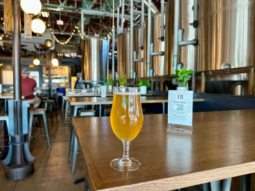 Craft beer on a table with brewing system behind at North Park Beer Company in the San Diego neighborhood of North Park