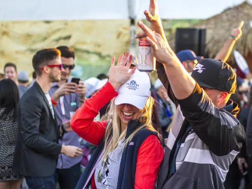 Couple with drinks in hand enjoying their time at the Farmers Insurance Open in San Diego