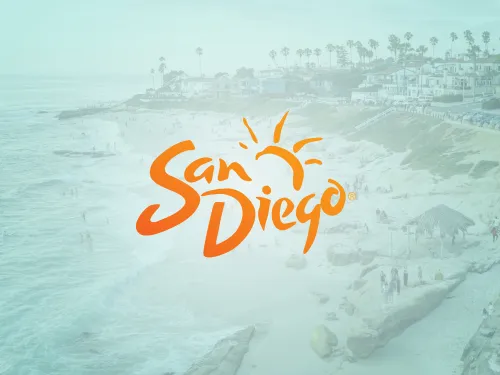 A beach scene with people walking and relaxing near the ocean, overlaid with the orange "San Diego" logo and a sun graphic.