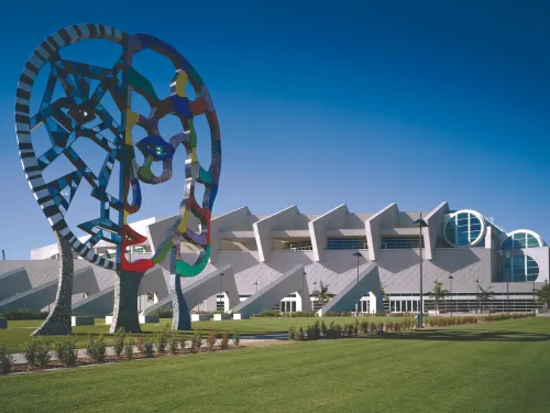 A work of public art stands in the foreground of the San Diego Convention Center under sunny blue skies.