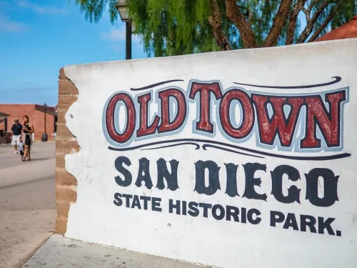 A sign reading "Old Town San Diego State Historic Park" sits streetside in the Old Town neighborhood of San Diego.