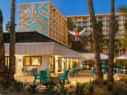 A view of the Town and Country Resort in San Diego at twilight, showing hotel buildings and landscaping.