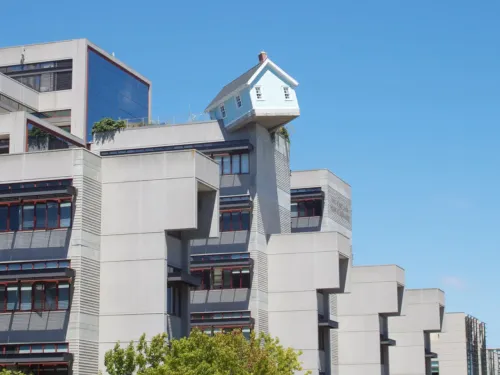 A view of "Fallen Star," a reproduction of a house that appears to hang from the edge of a building at the University of California San Diego. It is part of the Stuart Collection of public art.
