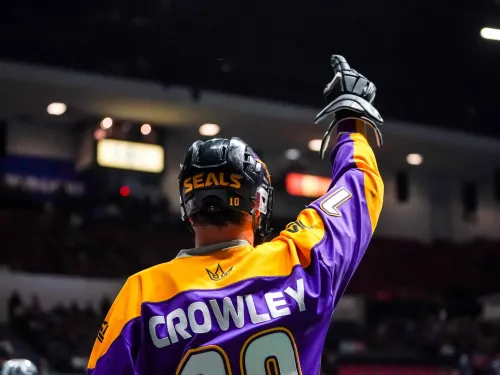 San Diego Seals player in a bright jersey raises one arm in celebration, facing an audience.