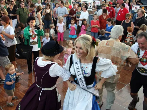 A lively dance event with people in traditional attire, enjoying the festivities.