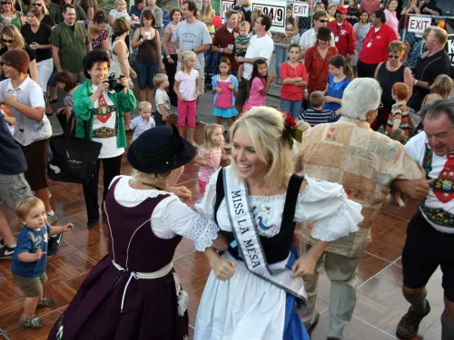 A lively dance event with people in traditional attire, enjoying the festivities.