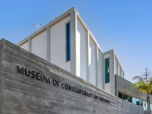 An exterior view of the Museum of Contemporary Art San Diego in La Jolla, showing white and gray exteriors under sunny blue skies.