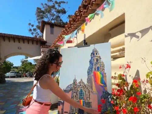 Gerry Isabelle in front of a painting of the California Tower in Balboa Park in SanDiego