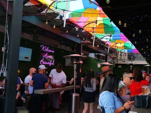 People sitting outside on the patio of the colorful restaurant of Gossip Grill in Hillcrest