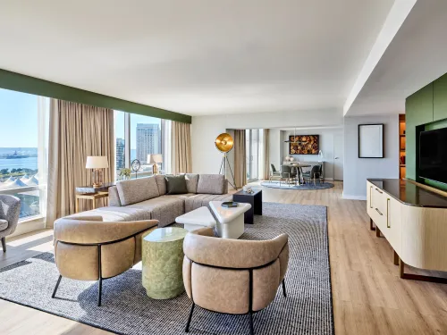 Modern open-concept living room with large windows, stylish furniture, and a scenic view.