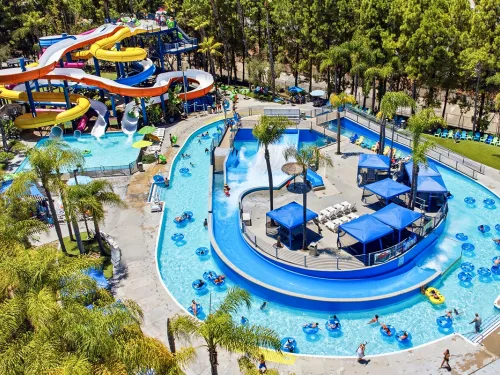 Aerial view of The Wave Waterpark featuring colorful slides and a lazy river surrounded by trees.