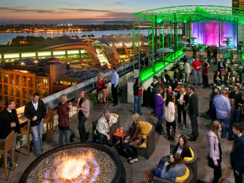 Aerial view of people on rooftop of Altitude Sky Lounge overlooking Downtown San Diego & the bay