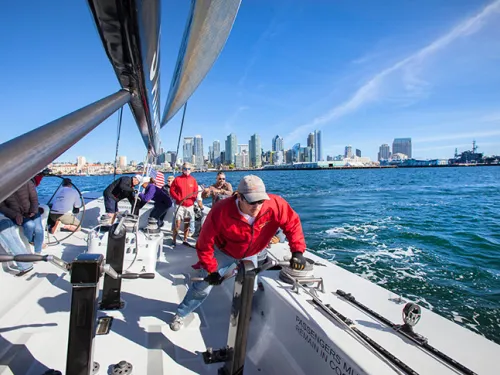 People aboard sailboat from America’s Cup Sailing San Diego with Downtown San Diego skyline