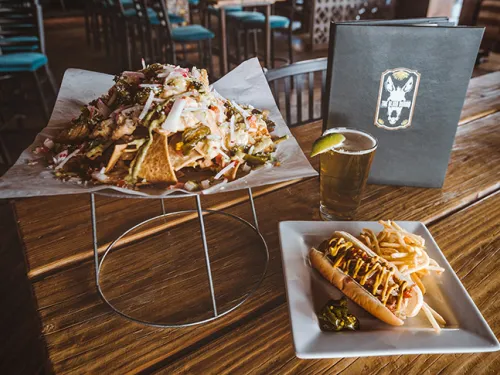 Close-up of food, nachos and hotdog with fries, on table at the The Blind Burro in San Diego, CA