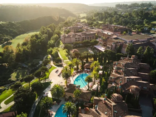 Aerial view of the Fairmont Grand Del Mar with pool surrounded in lush green canyons