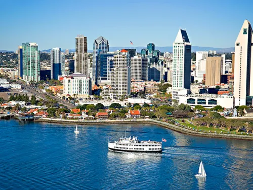 Boat from City Cruises moving forward on San Diego Bay against the skyline