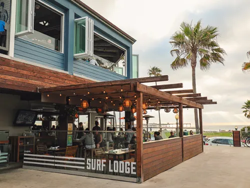 Outdoor patio of OB Surf Lodge with Ocean Beach in the background in San Diego, CA