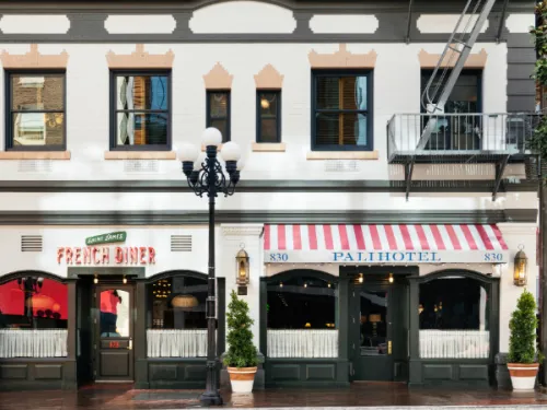 Front of the Palihotel San Diego in Downtown with a red striped entrance and lamp pos