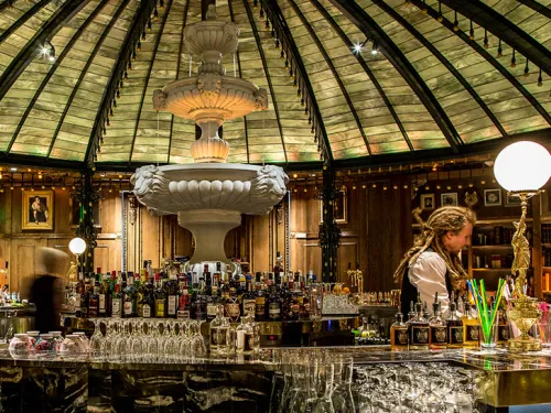 Stocked bar in a unique glowing setting at speakeasy Raised by Wolves in Westfield UTC Mall