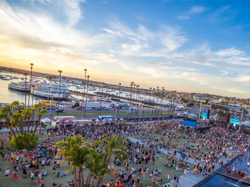 People standing in crowd at waterfront park in Downtown San Diego enjoying live music