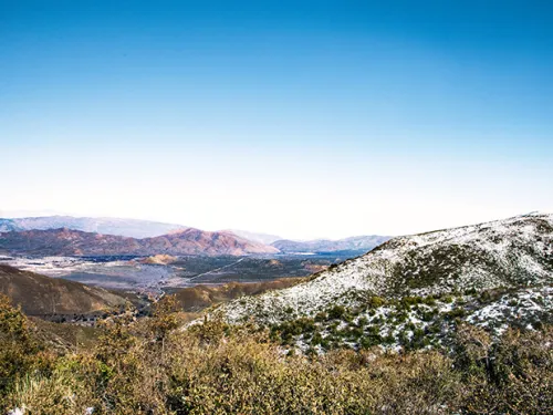 Mountains with greenery and snow known as Stonewall Peak Summit in San Diego, CA